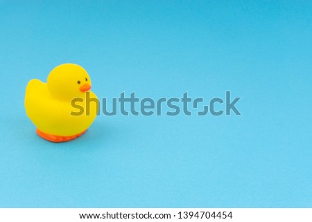 Yellow rubber duck on blue background. Selective focus, business and copy space concept