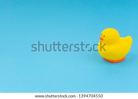 Yellow rubber duck on blue background. Selective focus, business and copy space concept