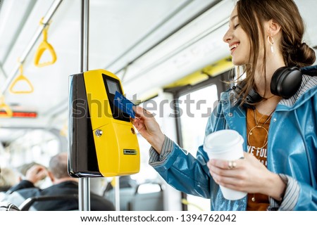 Woman paying conctactless with bank card for the public transport in the tram Royalty-Free Stock Photo #1394762042