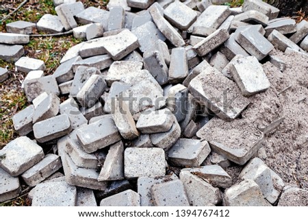 Old paving slabs are piled on the ground in the park. Royalty-Free Stock Photo #1394767412