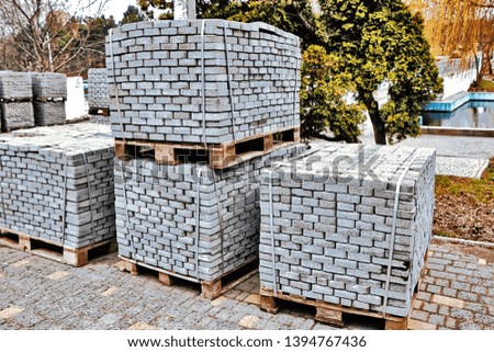 Repair work on laying paving slabs in the park. Tile blocks on pallets lie next to each other on the street. Royalty-Free Stock Photo #1394767436