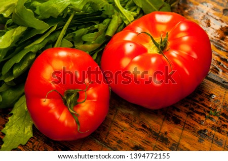 Healthy and diet food: arugula and tomatoes on wooden table