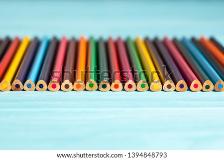 Colored pencils of all colors of the rainbow are on the table.