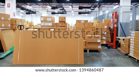 Paper board empty on blurred background. Perspective brown paper over blur in large warehouse logistic or distribution center,Can be used mock up for montage products display or design.