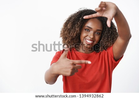 Girl imaging how apply opportunities to life, picturing image as making frame with fingers and looking through it smiling feeling creative and upbeat posing delighted over white background