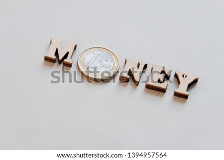 The word Money is written in wooden letters and a one Euro coin. Banner for printing. Texture background. Copy space.