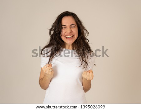 Young attractive latin woman celebrating success winning or feeling lucky and joyful dancing making celebration gestures with arms. Isolated on neutral background In People expressions and emotions.