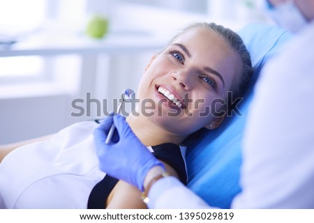 Young Female patient with pretty smile examining dental inspection at dentist office. Coronavirus COVID-19 virus pandemic Royalty-Free Stock Photo #1395029819