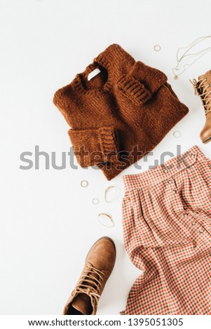 Fashion casual look composition with brown sweater, shoes, skirt, accessories on white background. Flat lay, top view. Modern minimalist collage.