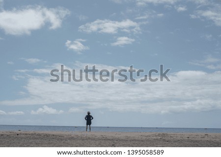 The man stands on the ocean shore. Horizon of the Atlantic Ocean. Photographer takes pictures of the sea. Cloudy skies and sand. A man waits for a ship and looks into the distance. Copy space.