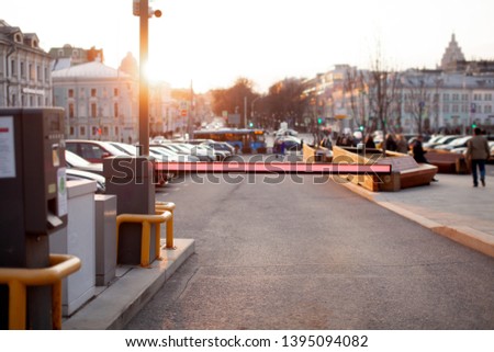 Close up of parking ticket machine and barrier gate at the entrance of parking area. Blurred concept view of modern europe cityscape. Business center of old town. 