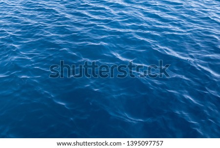 Ripples and small waves on blue water in the sea. Background image.