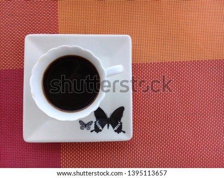 Coffee on top of a saucer with butterfly design