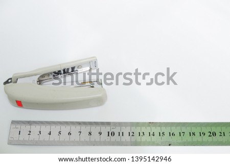 Ruler and stapler isolated on white background. Top view close up details.