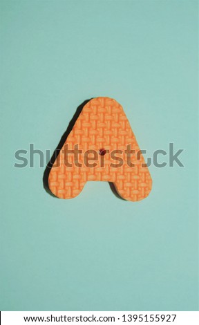 Orange capital letter A with blue background