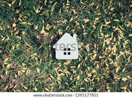 Concept of hard paper house on green grass , a symbol for construction , ecology, loan, mortgage, property or home.
