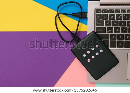 External hard drive with laptop on colorful background. Flat lay. The concept of backup storage.