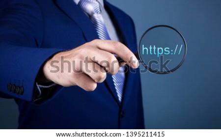 businessman against dark background with magnifier; web search