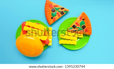  Pizza, french fries  and burger Toy on  blue Background. Set of children's plastic toys .Artificial Plastic Food 