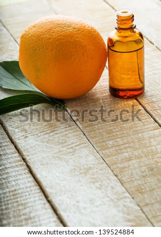 Essential aroma oil with orange on wooden background. Selective focus.