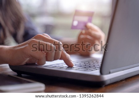 Woman's hands holding credit card and typing on the keyboard of laptop for shopping online. Pays for purchase Royalty-Free Stock Photo #1395262844