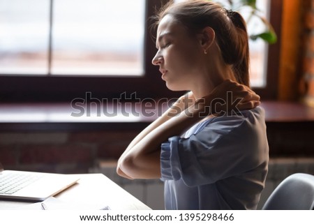 Tired woman feeling pain in neck pain after sedentary work with computer in uncomfortable posture or chair, exhausted female student or freelancer massaging tensed neck muscles, close up Royalty-Free Stock Photo #1395298466