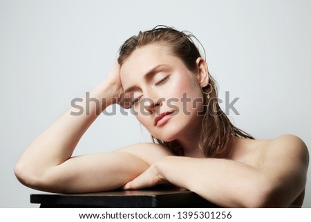 Handsome portrait of a pretty young topless woman with natural makeup over white background. Cosmetology and Advertisement.