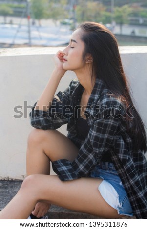 Portrait of thai china adult beautiful girl black shirt blue jeans relax and smile