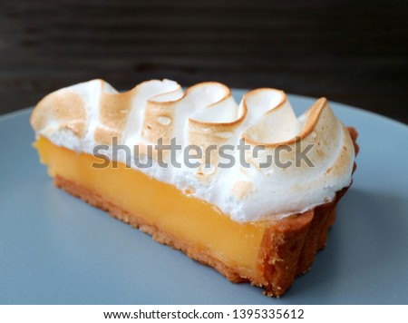 Closeup a Slice of Mouthwatering Lemon Meringue Tart on a Blue Plate