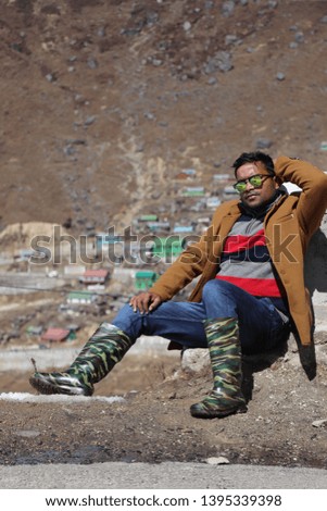 Young Indian man posing in to camera in Mountains.  This picture has been taken in Sikkim, India