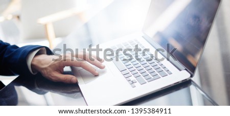 Businessman is using laptop and analysing the financial information at his office. Close up of male hands typing on computer keyboard