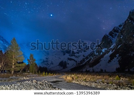 Mountain gorge Ullu-Tau Chana at night under the sky with clouds and stars in the Kabardino-Balkarian Republic, Caucasus, Russia, May 2019