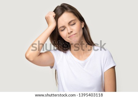 Young female closed eyes touches head with hand forgot something important she regrets about mistake feels stressed isolated on grey background studio shot, bad memory absent-mindedness concept image Royalty-Free Stock Photo #1395403118