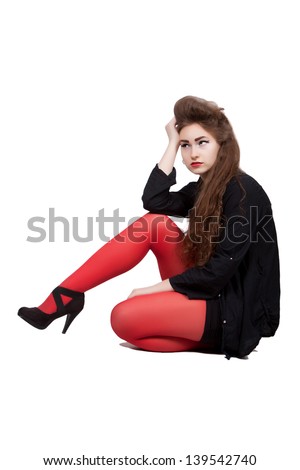 Teenage girl in black and red dress, sitting on the ground, it is sad, isolated on white background