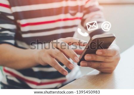 Close-up image of male hands using smartphone with icon telephone email mobile phone and address. Contact us connection and e-mail marketing concept