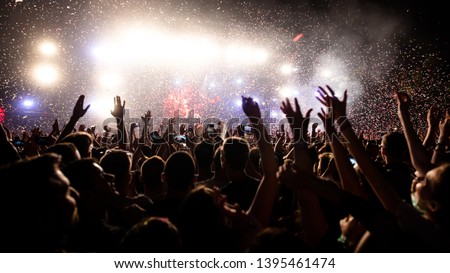 Crowd of people having fun while watching confetti fireworks at music festival. Copy space. Royalty-Free Stock Photo #1395461474
