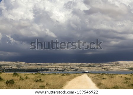 Remote landscape with stormy clouds and beautiful yacht