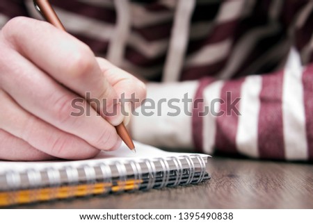 Closeup male writing in notebook. Concept in education and knowledge 