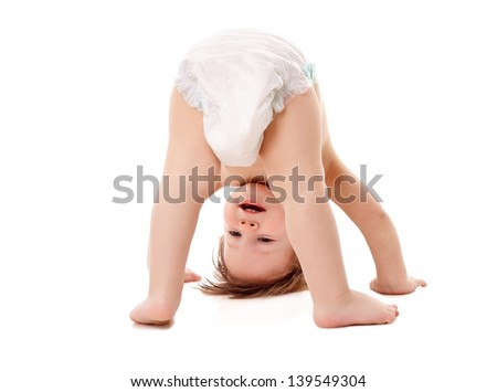 Funny playing baby standing on his head, isolated on white Royalty-Free Stock Photo #139549304
