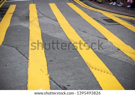 Yellow lines painted on the road, showing traffic rules guide for drivers and pedestrians to follow the laws.