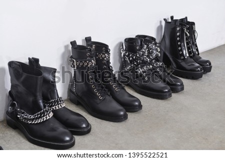 Row of black Rivets high hell shoes isolated-gray background