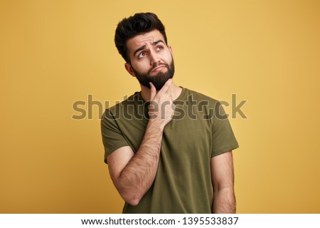 solution of problem. young cute man disposes of a problem, ound. looks up, makes up an idea. isolated yellow background Royalty-Free Stock Photo #1395533837