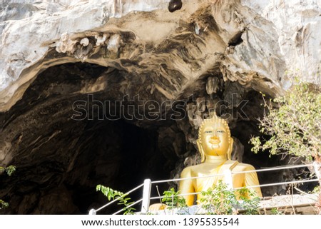 Golden Buddha statue in the cave in Thailand