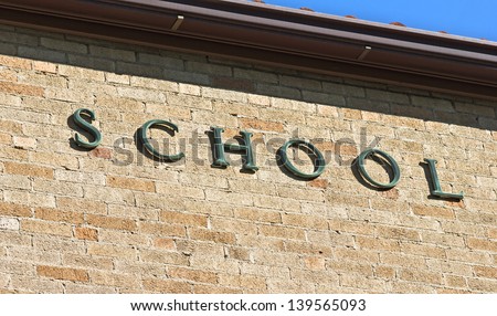 School sign on a brick wall