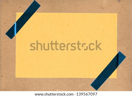 Yellow paper on cardboard background