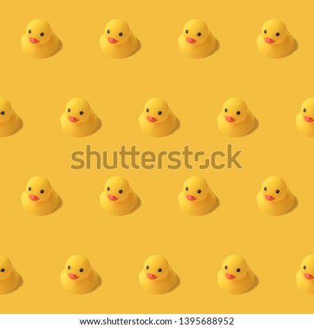 repeatable pattern of yellow rubber duck on yellow background Modern style. creative photography.