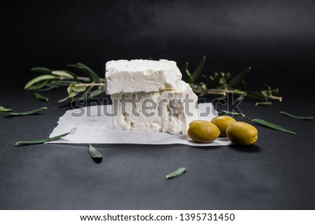Feta Greek cheese with olives on black background