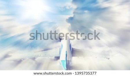 The travel by plane flies in the sky above the clouds.