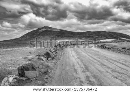 on the road to Papagayo beach with view to the volcanic mountain Hacha Grande on a cloudy day, black and white picture