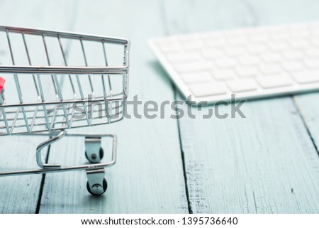 empty shopping cart and keypad on blue wooden table 